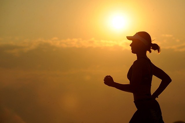 žena běžící při západu slunce